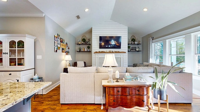 living room featuring baseboards, visible vents, dark wood finished floors, vaulted ceiling, and a large fireplace