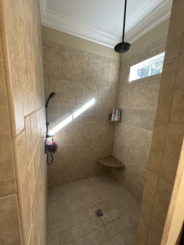 bathroom featuring ornamental molding and tiled shower