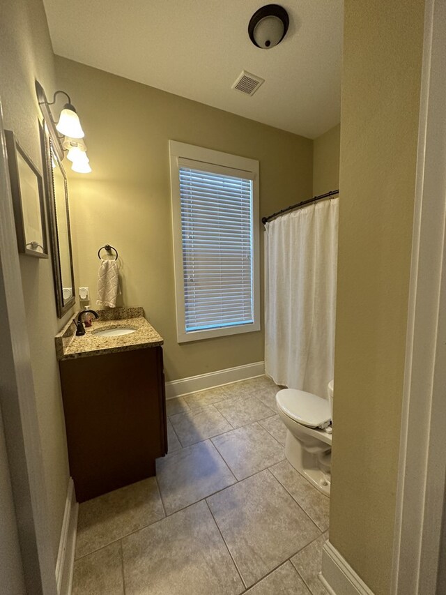 bathroom featuring vanity, tile patterned flooring, and toilet