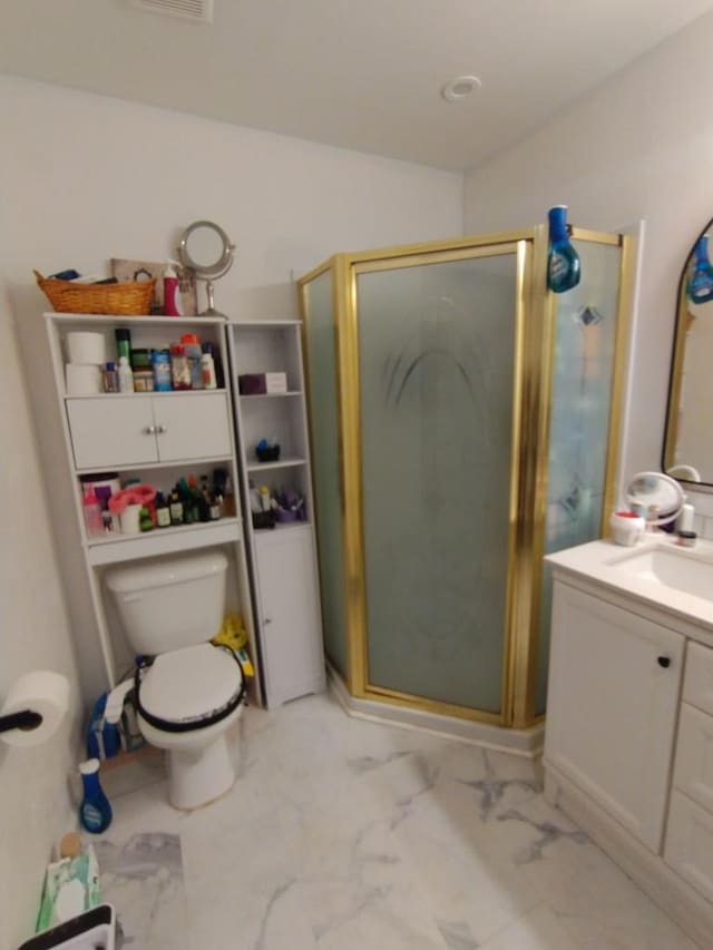 bathroom with a stall shower, marble finish floor, vanity, and toilet