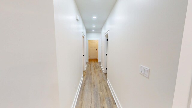 hallway with light hardwood / wood-style floors