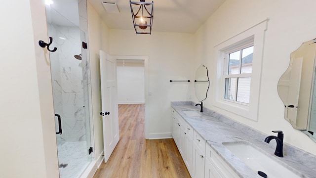 bathroom featuring hardwood / wood-style floors, a shower with shower door, and vanity