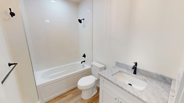 full bathroom featuring toilet, wood-type flooring, vanity, and tiled shower / bath