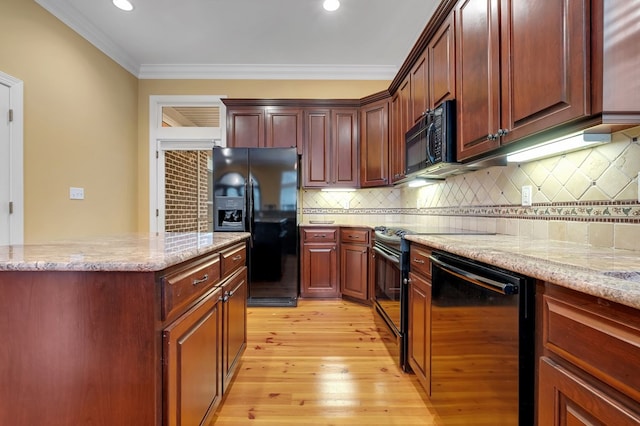 kitchen featuring crown molding, light stone countertops, light hardwood / wood-style floors, decorative backsplash, and black appliances