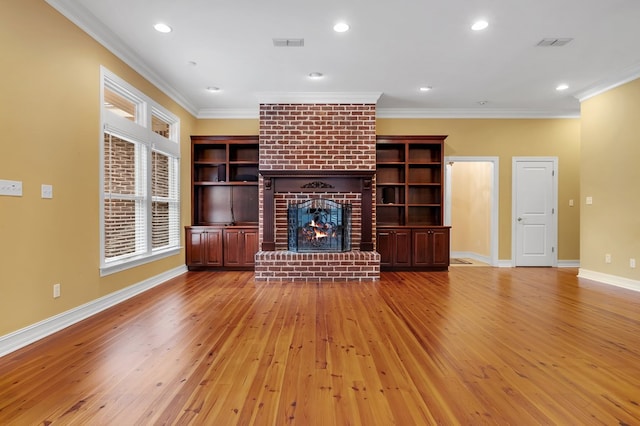 unfurnished living room with crown molding, light hardwood / wood-style floors, and a brick fireplace