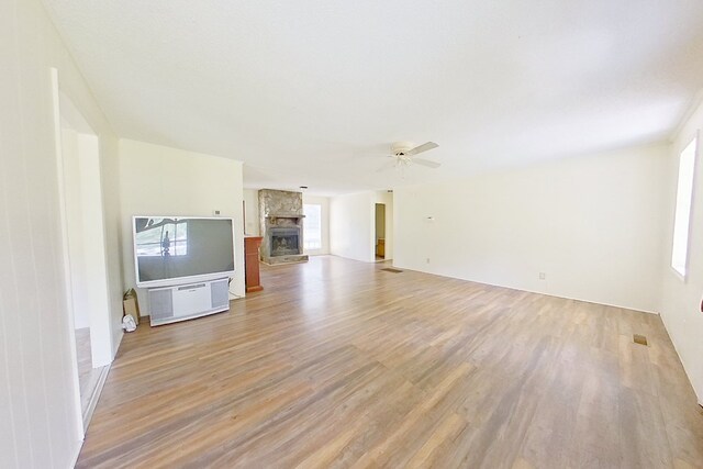 452 Bn Railroad Cir, Boston, GA 31626 - unfurnished living room with light wood-type flooring, ceiling fan, and a stone fireplace
