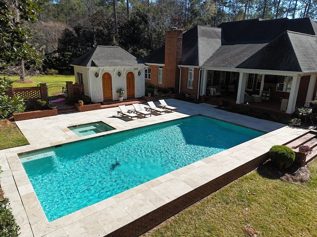 view of pool with an in ground hot tub, an outdoor structure, and a patio area