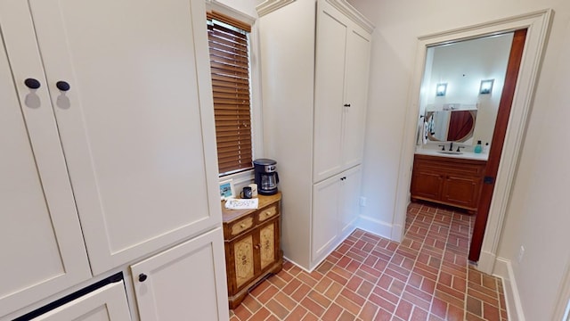 312 Avalon Way, Thomasville, GA 31792 - corridor featuring brick patterned floors, baseboards, and a sink