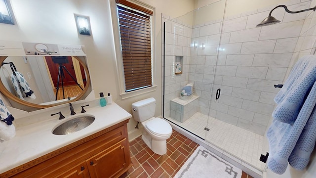 bathroom featuring vanity, a shower with door, and toilet