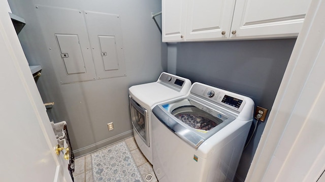 laundry room featuring light tile patterned floors, washing machine and dryer, cabinets, and electric panel