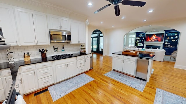 kitchen featuring white cabinetry, stainless steel appliances, and crown molding