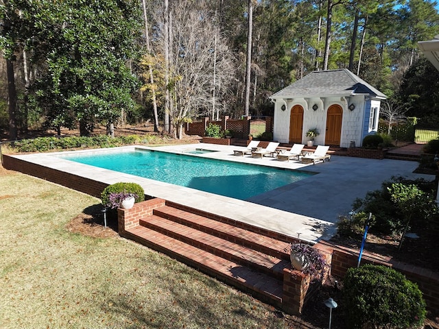 view of swimming pool with a patio area, an outdoor structure, and a hot tub