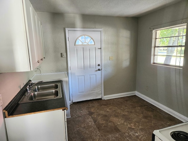 kitchen featuring sink, a textured ceiling, and white cabinets