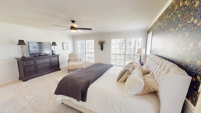 bedroom featuring baseboards, crown molding, a ceiling fan, and carpet floors