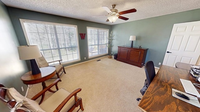 office space featuring visible vents, a ceiling fan, a textured ceiling, carpet, and baseboards