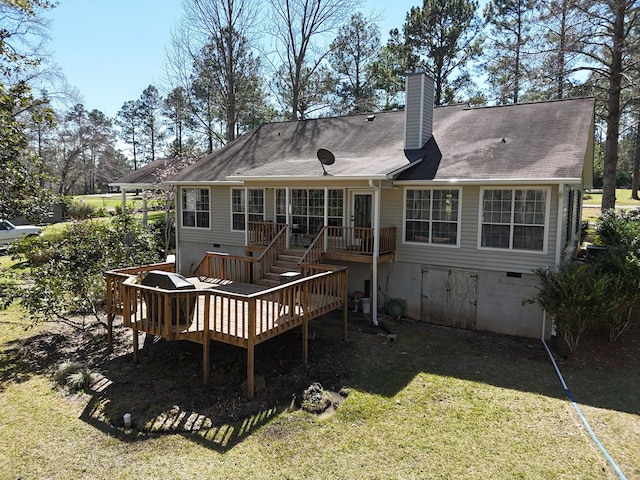 rear view of property with a deck, crawl space, a yard, and a chimney