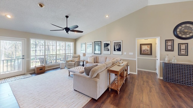 living area with a textured ceiling, baseboards, ceiling fan, dark wood-style flooring, and vaulted ceiling