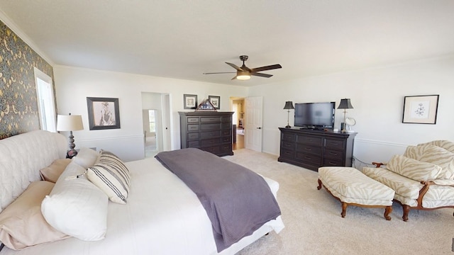 bedroom with light colored carpet, ensuite bath, and ceiling fan