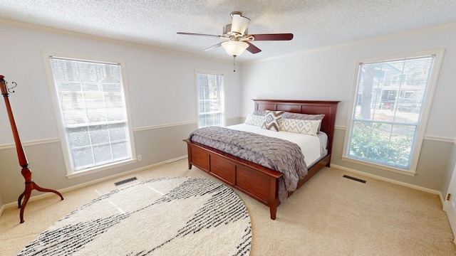 bedroom with visible vents, light carpet, and a textured ceiling