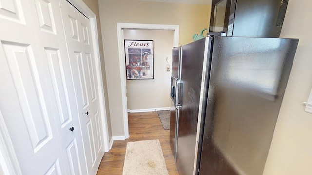 kitchen featuring baseboards, fridge with ice dispenser, and wood finished floors