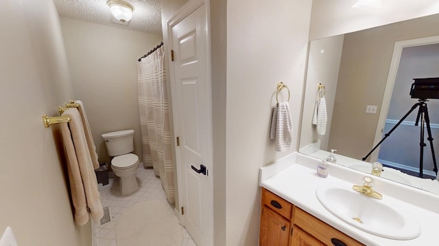 bathroom featuring tile patterned flooring, toilet, a textured ceiling, and vanity