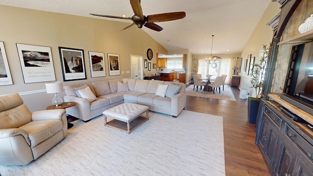 living area featuring high vaulted ceiling, wood finished floors, and ceiling fan with notable chandelier