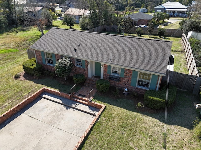 single story home with roof with shingles, a front yard, fence, and brick siding