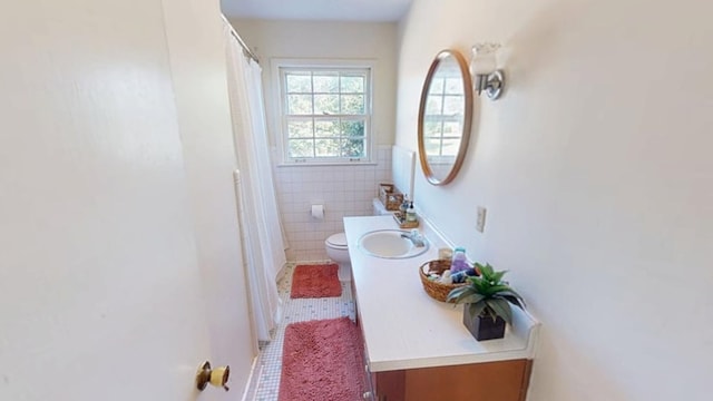 bathroom with tile walls, a shower with shower curtain, toilet, vanity, and tile patterned flooring