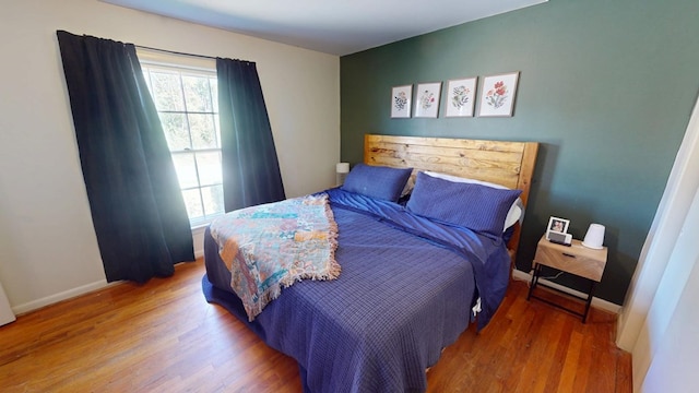 bedroom featuring baseboards and wood finished floors