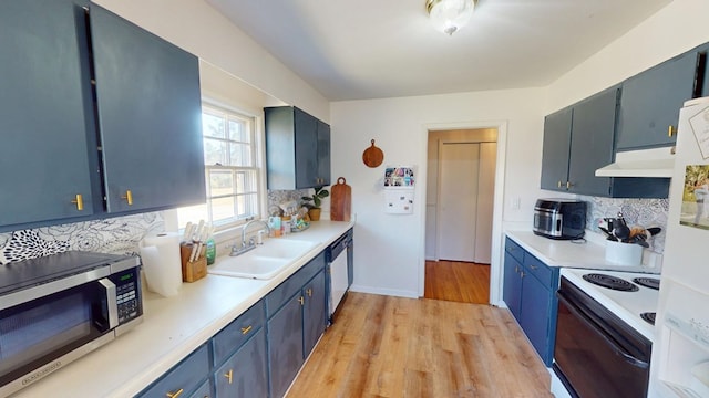 kitchen with electric stove, stainless steel microwave, decorative backsplash, a sink, and under cabinet range hood