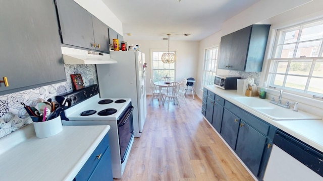 kitchen with under cabinet range hood, range with electric stovetop, light countertops, dishwasher, and tasteful backsplash