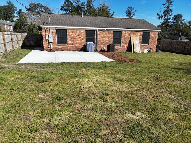 back of house with brick siding, a fenced backyard, and a patio