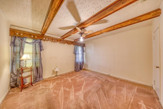 unfurnished room featuring ceiling fan, a healthy amount of sunlight, light carpet, and beam ceiling