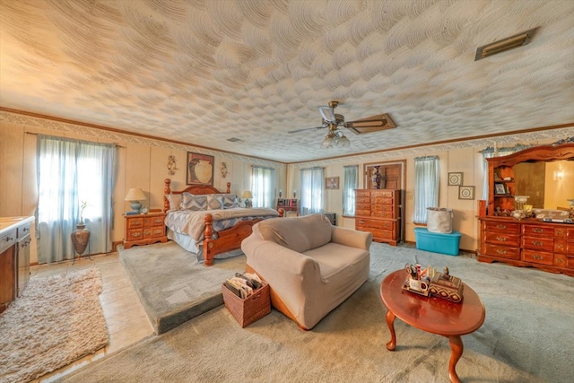 bedroom with ceiling fan, crown molding, and a textured ceiling