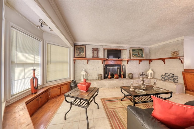 living room featuring crown molding, a textured ceiling, and light hardwood / wood-style flooring