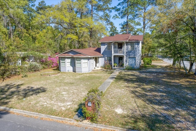 view of front of home featuring a front yard and a balcony