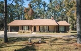 ranch-style home with a carport and a front yard