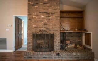 unfurnished living room with vaulted ceiling, wood-type flooring, and a fireplace