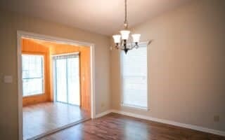 empty room with lofted ceiling, a notable chandelier, and dark hardwood / wood-style flooring