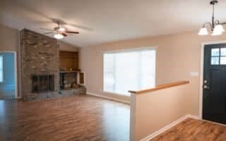 foyer with ceiling fan with notable chandelier, lofted ceiling, hardwood / wood-style floors, and a fireplace