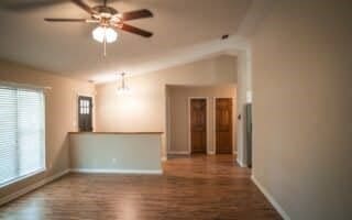 unfurnished living room featuring wood-type flooring, lofted ceiling, and ceiling fan