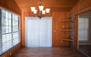 unfurnished dining area with an inviting chandelier, wood ceiling, a wealth of natural light, and wood walls