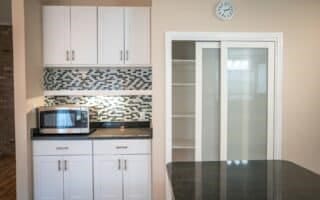 kitchen with tasteful backsplash and white cabinets