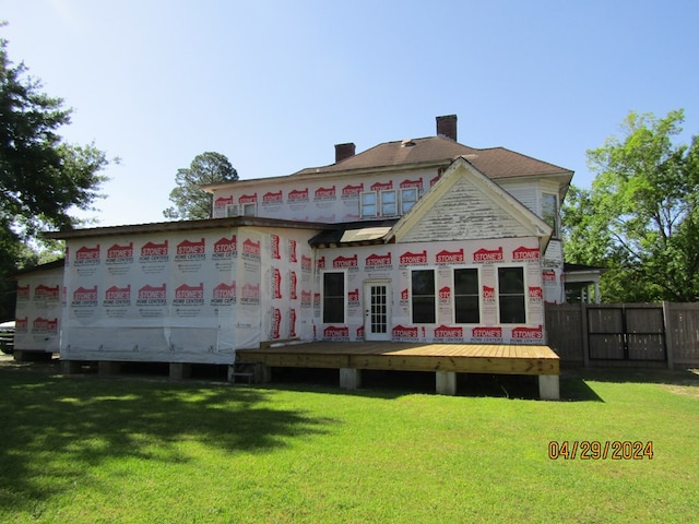 back of property featuring a yard and a deck