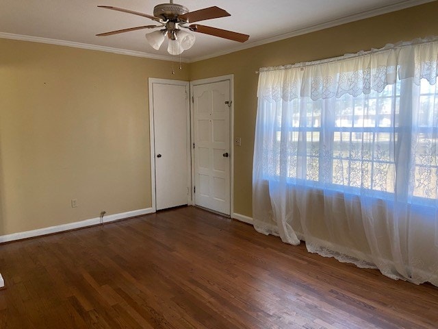 spare room featuring crown molding, dark wood-type flooring, and ceiling fan