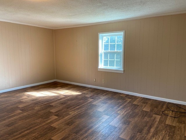 unfurnished room with crown molding, dark hardwood / wood-style flooring, and a textured ceiling