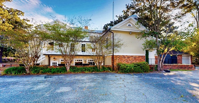 view of front of house featuring brick siding and a chimney