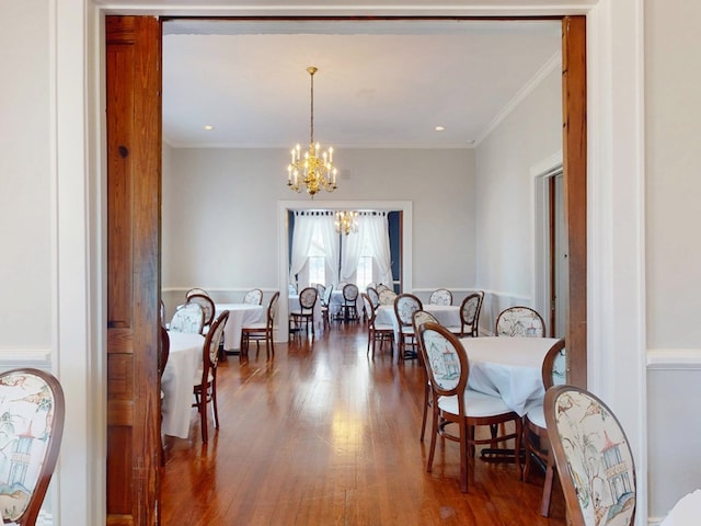 dining area with recessed lighting, a notable chandelier, crown molding, and wood finished floors