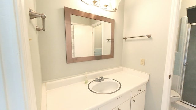 bathroom with vanity, toilet, and a stall shower