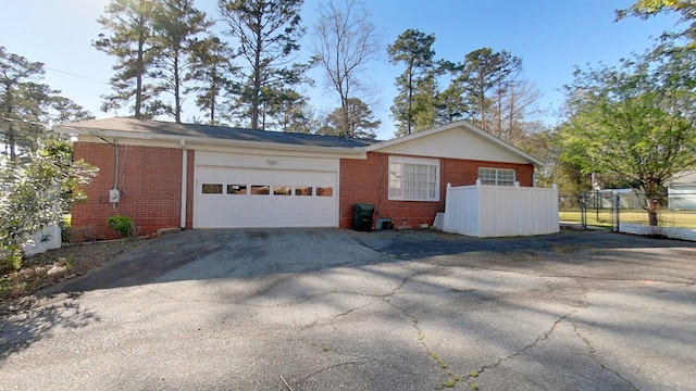 garage with aphalt driveway and fence